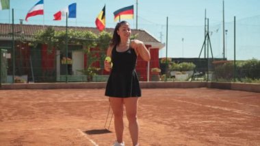 Bayan eğitmen, gündüz vakti Clay Court 'ta tenis öğretiyor..