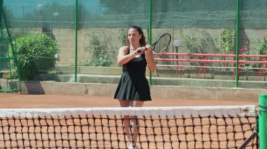 Bayan eğitmen, gündüz vakti Clay Court 'ta tenis öğretiyor..