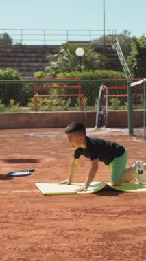 Bayan eğitmen, gündüz vakti Clay Court 'ta tenis öğretiyor..
