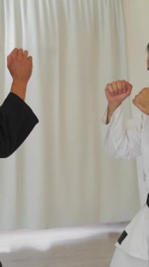 İki kıdemli karate uzmanı Kimono ile jimnastik yapıyor..