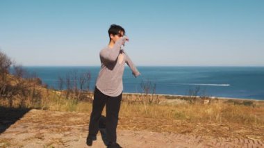 Genç çocuk kalenin yanındaki tepede Latin americano balesi yapıyor..