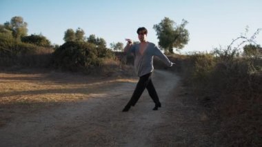 Genç çocuk kalenin yanındaki tepede Latin americano balesi yapıyor..