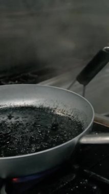 Şef siyah mürekkep balıklı spagetti pişiriyor..