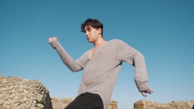 Genç çocuk kalenin yanındaki tepede Latin americano balesi yapıyor..