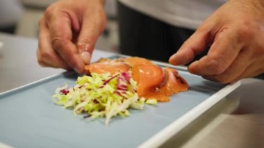 Şef deniz kenarında bir restoranda balık pişiriyor.