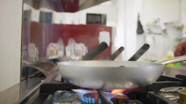 Şef deniz kenarında bir restoranda balık pişiriyor.