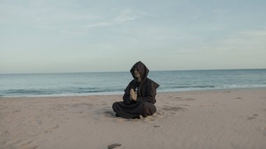 Keşiş akşamları sahilde oturmuş dua ediyordu.