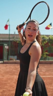 Bayan eğitmen, gündüz vakti Clay Court 'ta tenis öğretiyor..