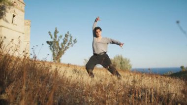 Genç çocuk kalenin yanındaki tepede Latin americano balesi yapıyor..