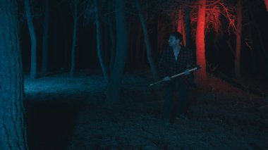 Korku ormanında Cadılar Bayramı delisi bir adam.