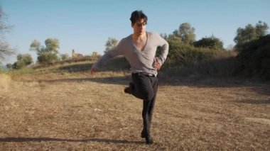 Genç çocuk kalenin yanındaki tepede Latin americano balesi yapıyor..