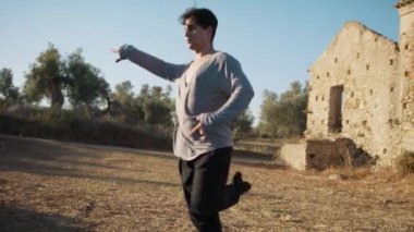 Genç çocuk kalenin yanındaki tepede Latin americano balesi yapıyor..