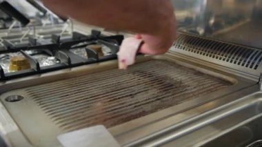 Şef deniz kenarında bir restoranda balık pişiriyor.