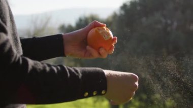 Kız kırsaldaki portakal meyvelerini soyuyor..