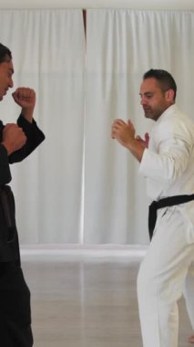 İki kıdemli karate uzmanı Kimono ile jimnastik yapıyor..