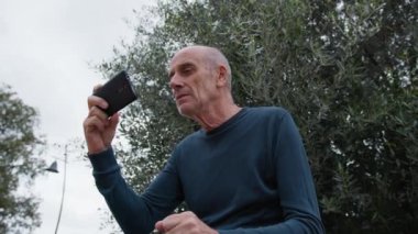 Yaşlı beyaz adam farklı bir yüz ifadesi takınıyor..