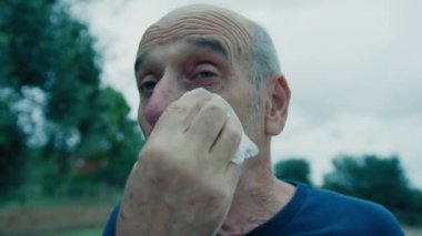 Yaşlı beyaz adam farklı bir yüz ifadesi takınıyor..