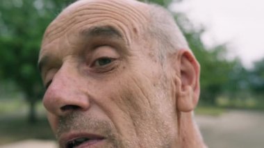 Yaşlı beyaz adam farklı bir yüz ifadesi takınıyor..