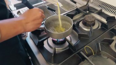 Şef bir restoranın mutfağında polenta pişiriyor..