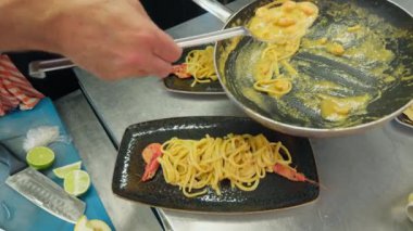 Restoran için siyah tabakta midyeli İtalyan spagettisi..