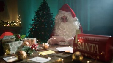 Noel Baba mektupları okuduktan sonra şöminenin başında kendini ısıtır.