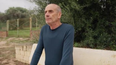Yaşlı beyaz adam farklı bir yüz ifadesi takınıyor..