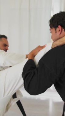 İki kıdemli karate uzmanı Kimono ile jimnastik yapıyor..