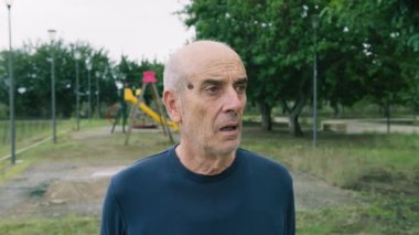 Yaşlı beyaz adam farklı bir yüz ifadesi takınıyor..