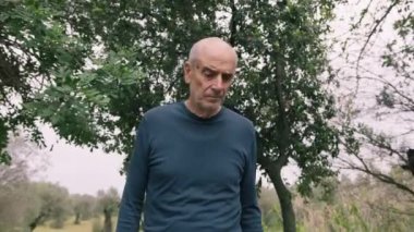 Yaşlı beyaz adam farklı bir yüz ifadesi takınıyor..