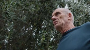 Yaşlı beyaz adam farklı bir yüz ifadesi takınıyor..