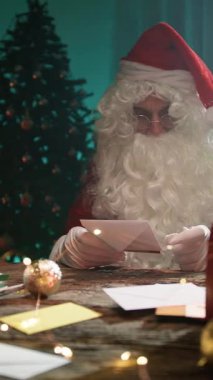 Noel Baba mektupları okuduktan sonra şöminenin başında kendini ısıtır.