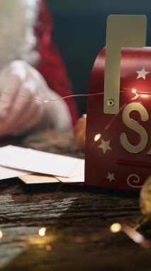 Noel Baba mektupları okuduktan sonra şöminenin başında kendini ısıtır.