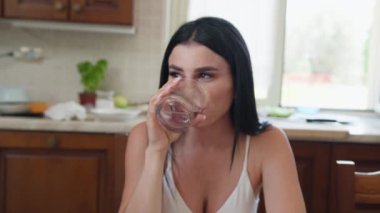 İki genç İtalyan kadın mutfaktaki masada yemek yiyorlar.