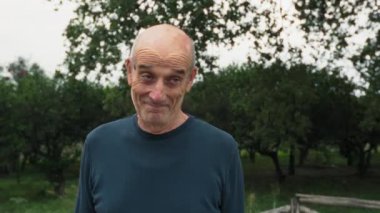 Yaşlı beyaz adam farklı bir yüz ifadesi takınıyor..