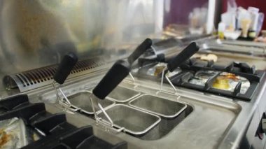 Şef deniz kenarında bir restoranda balık pişiriyor.