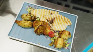 Şef deniz kenarında bir restoranda balık pişiriyor.