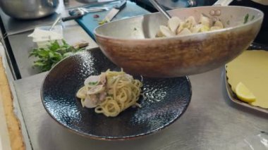 Restoranın tavasında midyeli makarna ve balık pişirmek..