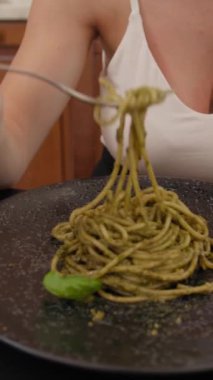 İki genç İtalyan kadın mutfaktaki masada yemek yiyorlar.