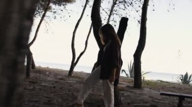 Sahilin yanındaki doğada bas gitar çalan bir kız..