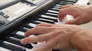 Beyaz gömlekli çocuk dışarıdaki doğada piyano çalıyor..