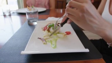 İki genç İtalyan kadın mutfaktaki masada yemek yiyorlar.