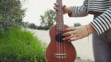 Mutlu kız doğada gitar çalıyor..