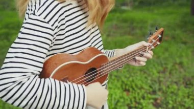 Mutlu kız doğada gitar çalıyor..