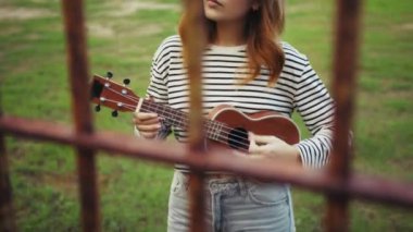 Mutlu kız doğada gitar çalıyor..
