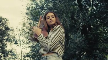 Mutlu kız doğada gitar çalıyor..