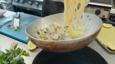 Restoran için siyah tabakta midyeli İtalyan spagettisi..