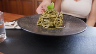 İki genç İtalyan kadın mutfaktaki masada yemek yiyorlar.