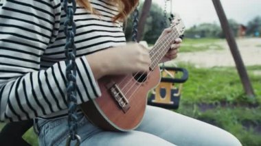 Mutlu kız doğada gitar çalıyor..