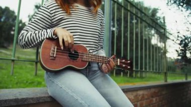 Mutlu kız doğada gitar çalıyor..