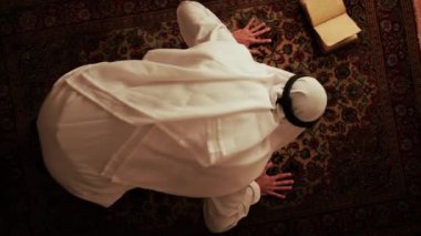 Adam elinde kitapla Ramazan dini için dua ediyor..